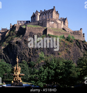 Iconico punto di riferimento e il famoso storico edificio fortezza il castello di Edimburgo sulla affioramento di granito domina lo skyline della città parte della Fontana nel parco sottostante la Scozia Foto Stock