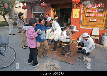 Cina Pechino minuscolo ma occupato quartiere ristorante con chef impostato sul marciapiede per preparare la colazione gnocchi Foto Stock