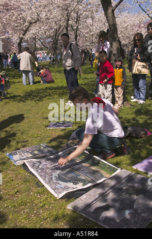 Artista pittura fiori di ciliegio lungo il fiume Potomac Tidal Basin durante l annuale Cherry Blossom Festival di Washington DC Foto Stock