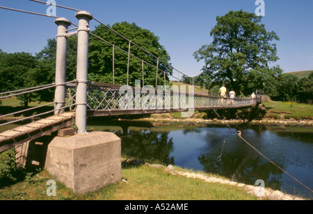 Semplice sospensione ponte sopra il fiume Wharfe, vicino Hebden, Wharfedale, North Yorkshire, Inghilterra, Regno Unito. Foto Stock