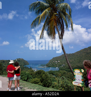 Giovane con le braccia intorno a ogni altro ammirare la vista sul delizioso Marigot Bay & porto di St Lucia Caraibi Foto Stock