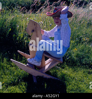 Ragazzo a cavallo su un horselike sedia a dondolo. Foto di Willy Matheisl Foto Stock