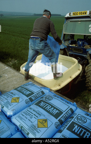 Agricoltore il caricamento di uno spanditore con alta fertilizzante di azoto Foto Stock