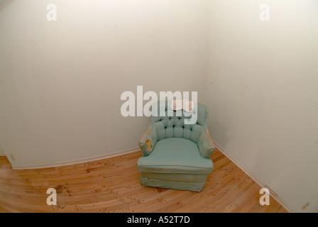 Vecchia sedia nella stanza vuota corner vecchia casa strappati indossato poveri povertà lonely vacuità abbandonato Foto Stock