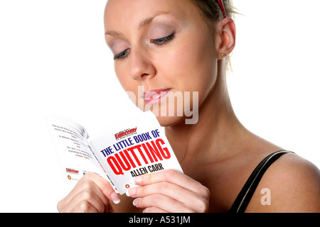 Giovane donna la lettura di smettere di fumare prenota modello rilasciato Foto Stock