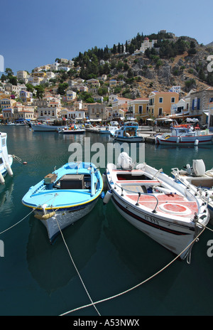 Coloratissime barche di pescatori ormeggiate nel porto di Yialos in Sými città sull'isola greca di Sými Foto Stock