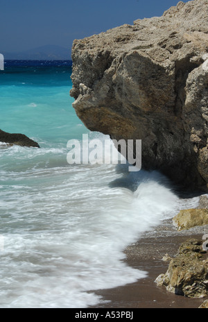 Onde che si infrangono sulle rocce su una spiaggia vicino alla città di Rodi in Grecia Foto Stock