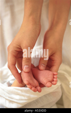 Madre teneramente contiene piccoli piedini del suo bambino la Russia Foto Stock