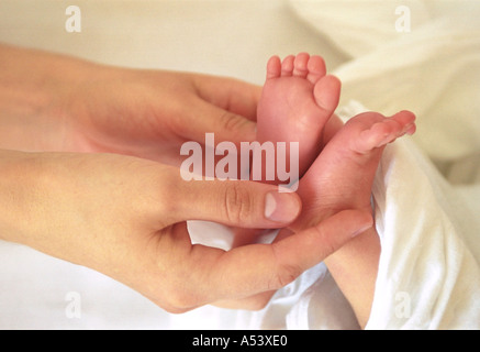 Madre teneramente contiene piccoli piedini del suo bambino la Russia Foto Stock