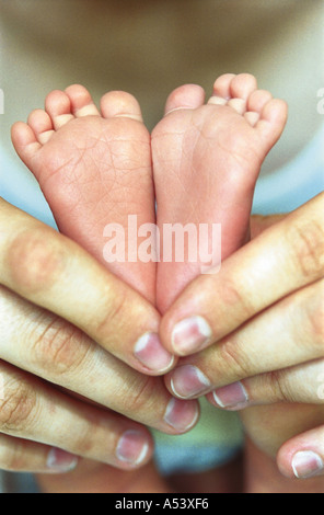 Madre teneramente contiene piccoli piedini del suo bambino la Russia Foto Stock