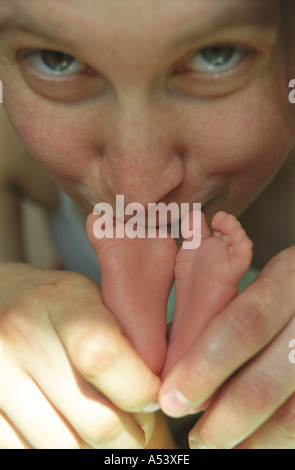 Madre teneramente contiene piccoli piedini del suo bambino la Russia Foto Stock