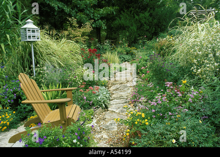 Giardino di Roccia curve del percorso attraverso il giardino fiorito con sedia e birdhouse Stati Uniti d'America Foto Stock