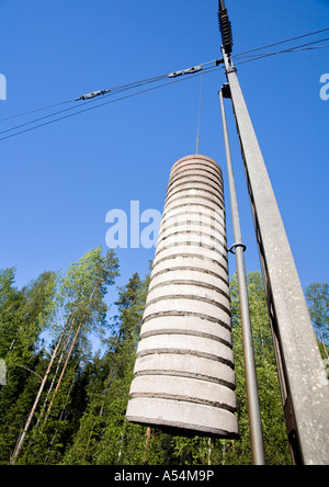 Contrappesi in calcestruzzo appesi ad una puleggia che mantiene i cavi elettrici della catenaria della ferrovia stretti e in tensione corretta , Finlandia Foto Stock