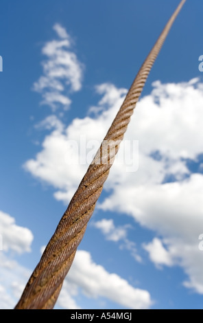 Rusty fune di acciaio cavo fino al cielo contro il cielo blu e nuvole bianche Foto Stock