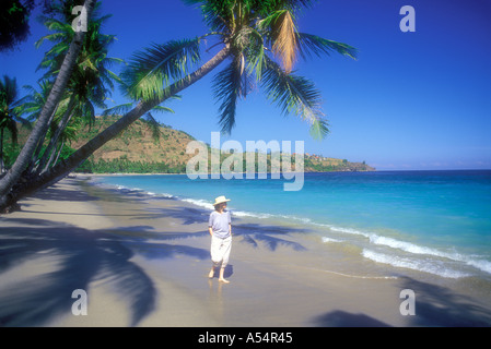 Donna che cammina lungo Pantai Nipah Beach sull'Isola di Lombok Indonesia Modello rilasciato foto Foto Stock