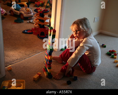 Ragazza giovane frustrato giocando con lego in home Foto Stock