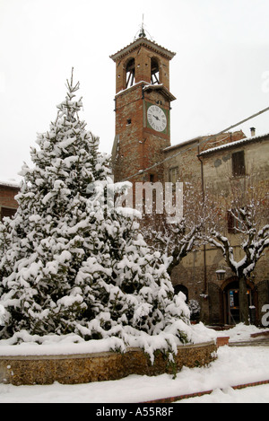 La piazza centrale a Citerna dopo la nevicata il camponile clock tower sorge su una fontana ricoperta in rami di abete per il Foto Stock