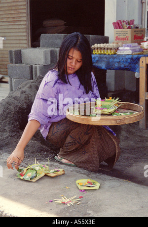 Donna che stabilisce un offerta in Bali Indonesia Foto Stock