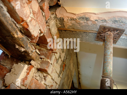 Puntelli ACROW tenendo un architrave di calcestruzzo in cui una porta con un vecchio architrave in legno ha bisogno di essere riparato Foto Stock