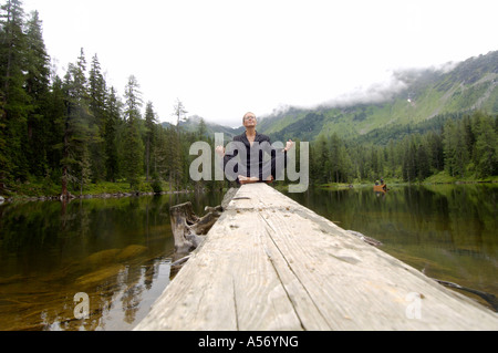 Imprenditrice meditando sul lago Foto Stock