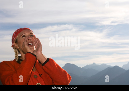 Giovane donna in montagna gridando a basso angolo di visione, ritratto Foto Stock