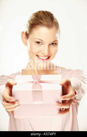 Giovane donna azienda confezione regalo, close-up, ritratto Foto Stock