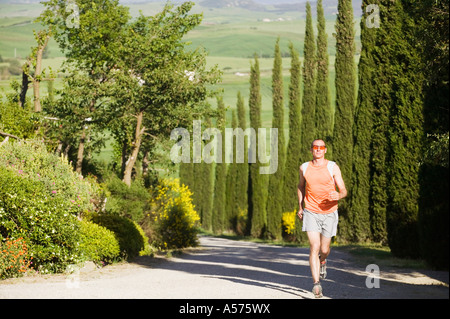 L'Italia, Toscana, uomo jogging sulla strada Foto Stock