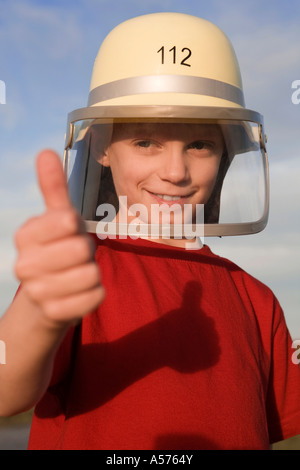 Ragazzo (10-13) indossando il casco pollice in alto Foto Stock