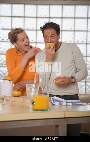 Coppia matura in cucina, uomo mangiare pompelmo Foto Stock