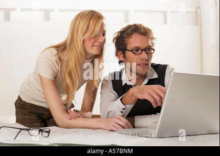 Giovane uomo e donna con laptop, sorridente Foto Stock