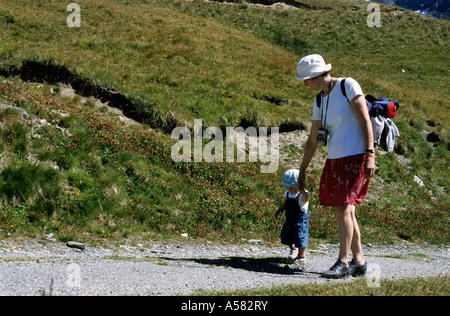 Nonna tenendo le mani di suo nipote durante le escursioni in montagna. Foto Stock