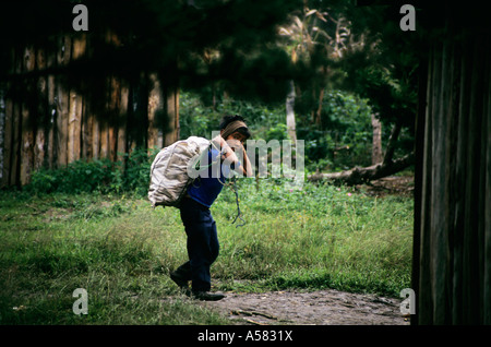 Ragazzo guatemalteco portando una borsa pesante per il suo ritorno in un campo profughi a Santa Esmeralda, Chiapas, Messico. Foto Stock