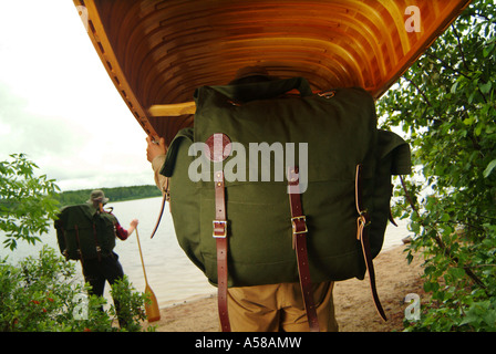 Portaging una canoa di legno in acque di confine canoa Area Wilderness BWCAW Minnesota Foto Stock