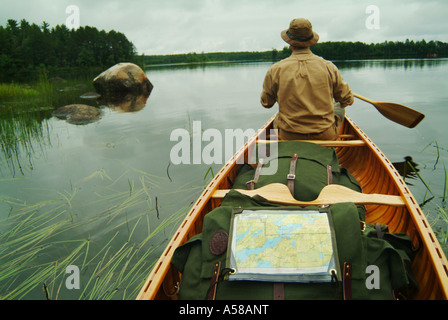 Pagaiando una canoa in acque di confine canoa Area Wilderness BWCAW Minnesota Foto Stock