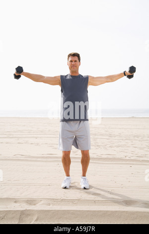 L'uomo esercita sulla spiaggia Foto Stock