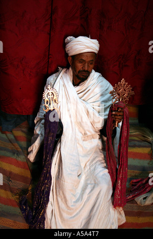 Lalibela, Etiopia, sacerdote tenendo un cross uno all'interno della roccia scavate chiese Foto Stock