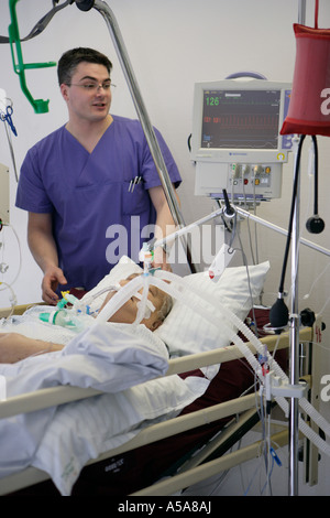 Un maschio di infermieri e di un paziente in unità di terapia intensiva Foto Stock