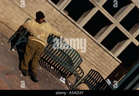 Un uomo di addormentarsi su un banco di lavoro a Johannesburg in Sud Africa Foto Stock