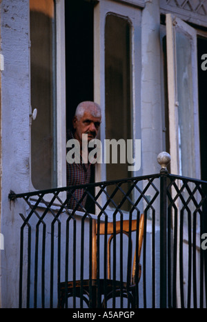 Un uomo del peering fuori del suo windows di un vecchio edificio a Beirut Libano Foto Stock