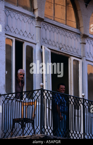 Un uomo del peering fuori del suo windows di un vecchio edificio a Beirut Libano Foto Stock