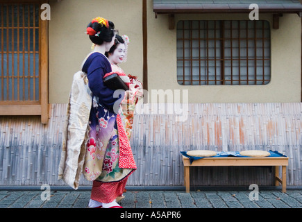 Due donne abbigliate come Maiko / Geisha passeggiate nello storico quartiere di Higashiyama di Kyoto, la regione di Kansai, Giappone Foto Stock