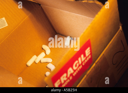 Svuotare la scatola di cartone o la scatola di cartone aperta per la consegna o la conservazione con alcuni pellet di schiuma di polistirolo all'interno. Adesivo fragile usato sull'esterno, primo piano Foto Stock