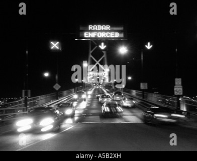 Occupato di sfocatura del traffico notturno di guida off bridge. Foto Stock