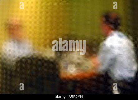 Vista della riunione aziendale attraverso la privacy di vetro. Foto Stock