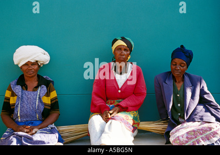 Tre donne seduti insieme contro la parete di turchese, Sud Africa Foto Stock