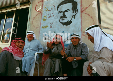 Gli uomini di bere il caffè con una foto di Hafez al'Assad in background in Siria. Foto Stock