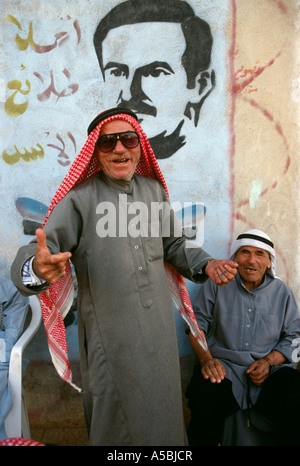 Uomini di raccolta con una foto di Hafez Al Assad in background Foto Stock