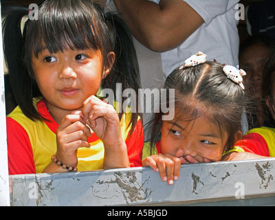 Due giovani ragazze peer attraverso aprire finestra carrello della Birmania Stazione treni turistici della Thailandia Foto Stock