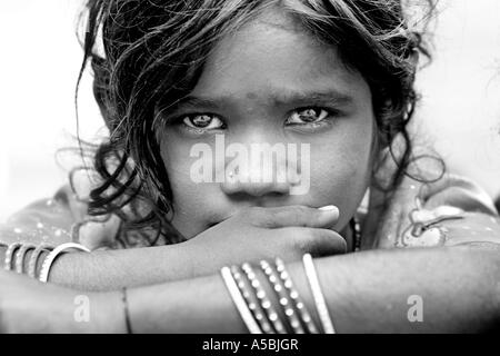 Girato in bianco e nero di little indian street girl fissando intensamente alla fotocamera Foto Stock