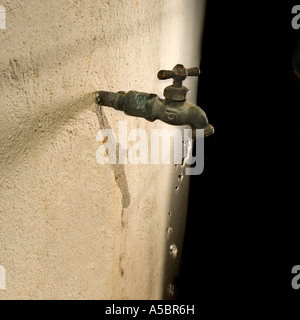 L'acqua che scorre dal rubinetto in ottone, penuria di conservazione e di razionamento, politico problema globale Foto Stock